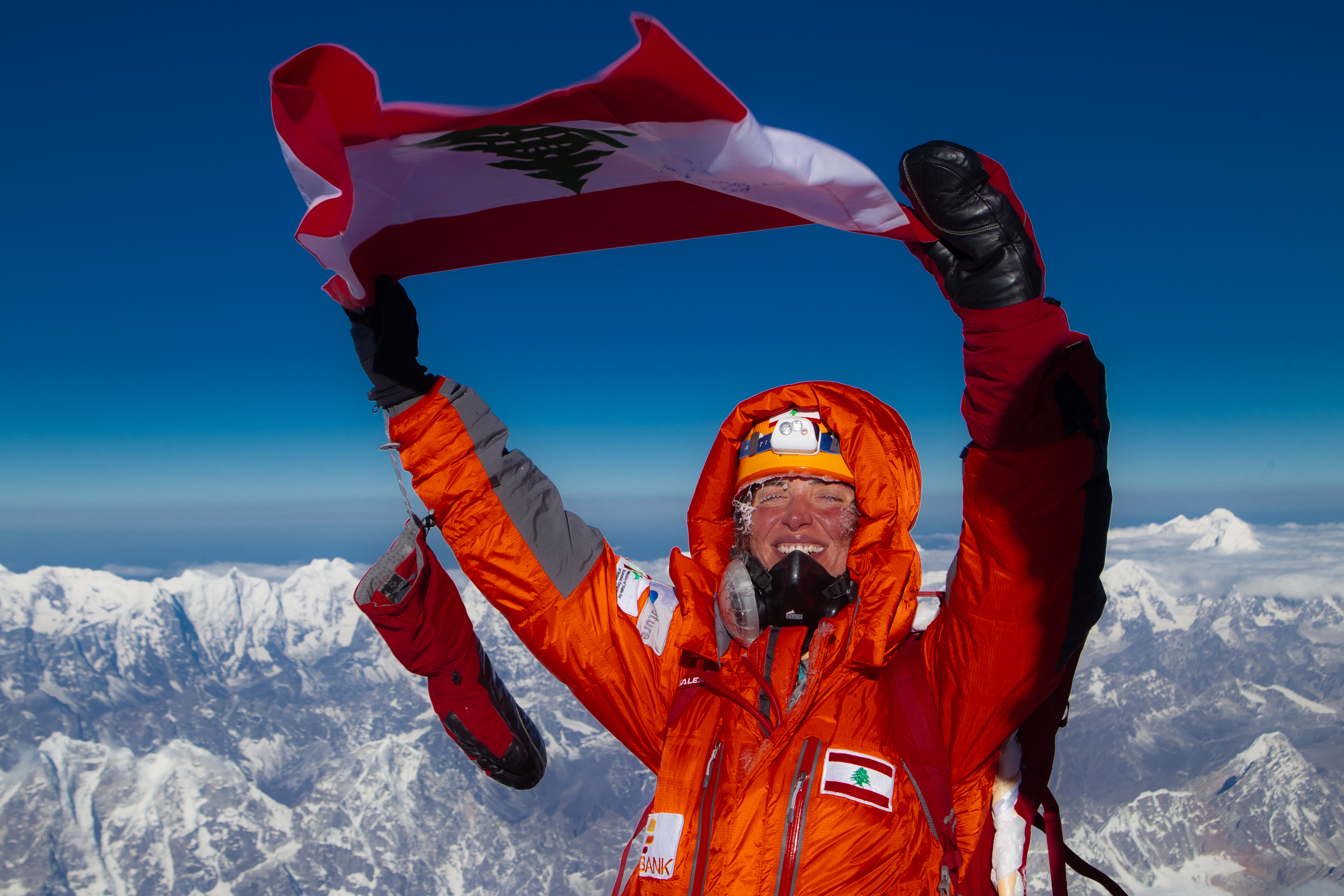Dr. Joyce Azzam at the summit of Everest holding the Lebanese flag
